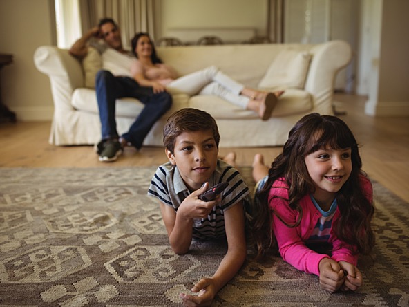 Parents and children watching TV_Crop